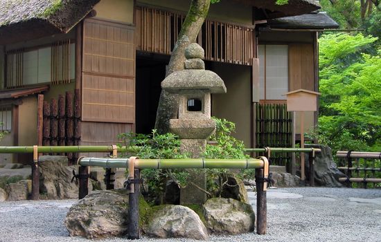 Very traditional Japanese tea house with stone lantern in front of it.Location:Golden Temple garden,Kyoto,Japan          