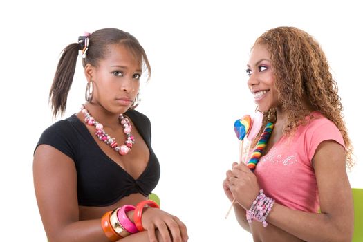 Two pretty black girls; one has candy and the other has nothing