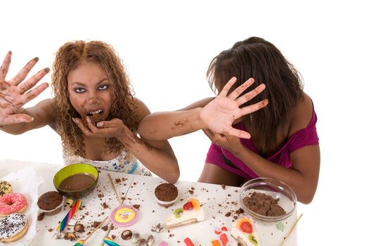 Two attractive black girls trying to hide while eating lots of junkfood
