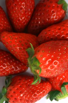 Close-up of brightly red strawberries on a white background.