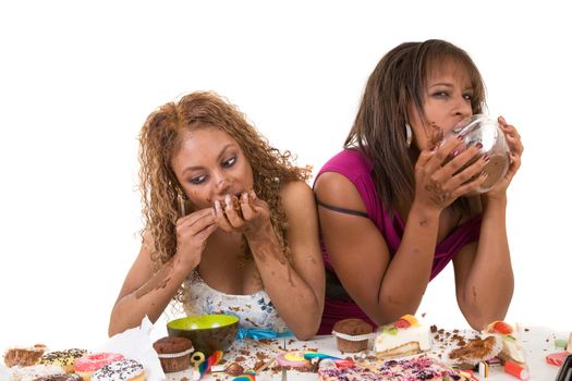 Two black girl eating sweets completely out of control