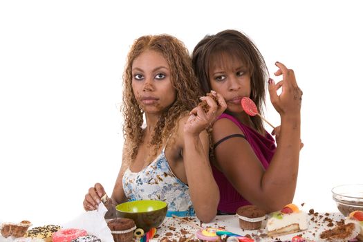 Two girls sitting back to back and stuffing themselves with food