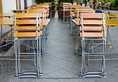 Small empty summer cafe with collapsible wooden chairs and tables
