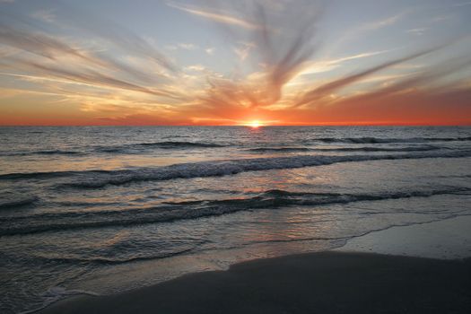 Beautiful colors make up this powerful  sunset with wispy clouds reaching out from the horizon.