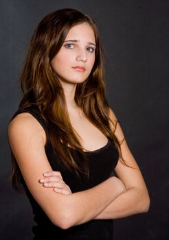 Young beautiful girl in a black vest on a black background
