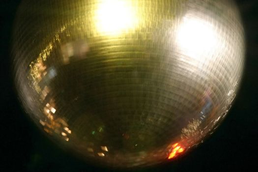 Golden reflecting disco ball photo in slight motion blur. Excelllent fot 70's themes or entertainment