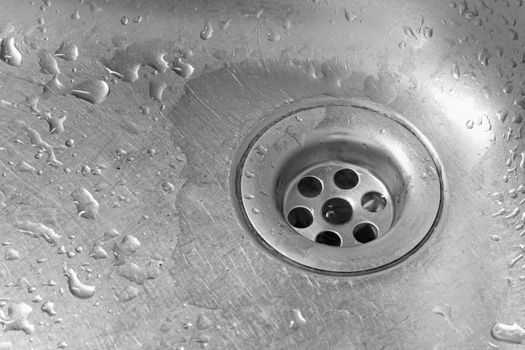 Metallic Kitchen sink with water drops shot from from low angle