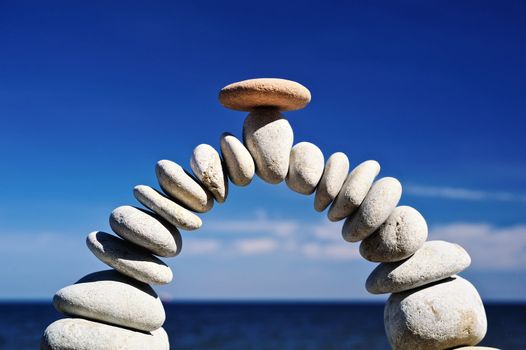 Arch of gravel with a stone in the middle on the seashore