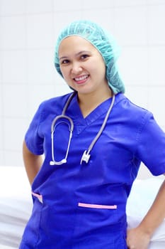 confident smiling asian nurse in blue scrub suit