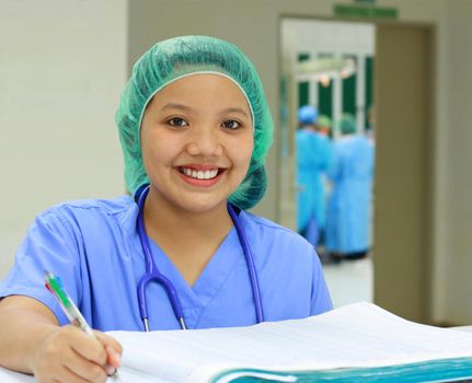 asian nurse recording in patients' logbook