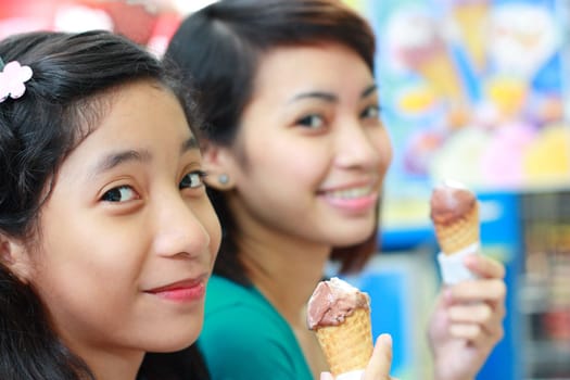 asian girls enjoyin a cone of ice cream
