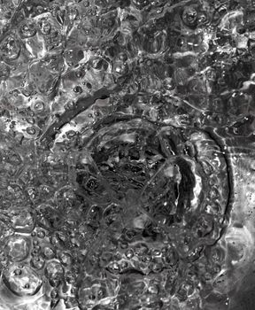 Metallic Kitchen sink water flow and drops shot from above, abstract -useful as background