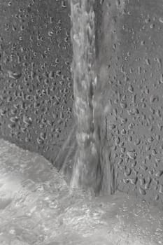 water flow over metallic wall into bassin with water drops and bubbles