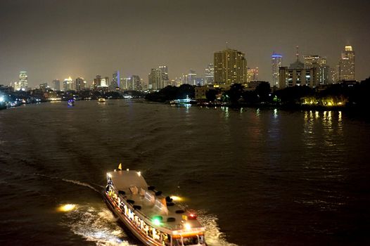 Boat at night on the Chao Phraya River in Bangkok, Thailand.