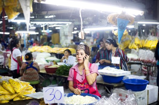 Bangkok, Thailand  -  March 15, 2011: Seller using her smartphone at local market in Bangkok Chinatown .Bangkok�s Chinatown is a popular tourist attraction and a food haven