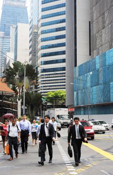 Singapore ,Republic of Singapore - May 3, 2011: People crossing the street in Singapore city at rush hour