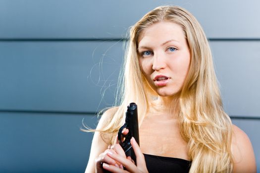 Sexy blonde woman as a secret agent spy holding hand gun firearm