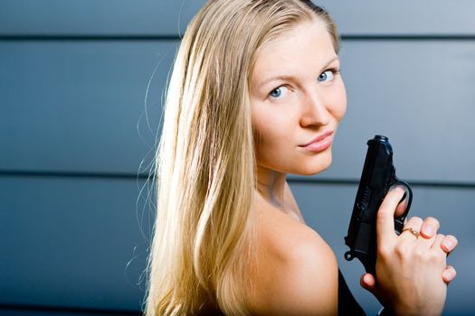 Sexy blonde woman as a secret agent spy holding hand gun firearm