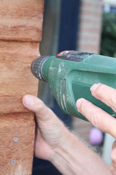 Working with a Power drill on a wooden construction
