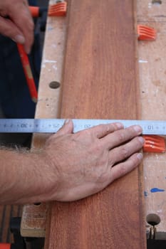 A Carpenter Getting Ready For Work, measuring wood
