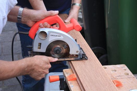 construction worker cutting wood with circular saw