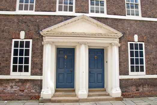 A Georgian Era Palladian Doorway with columns and two blue panelled doors