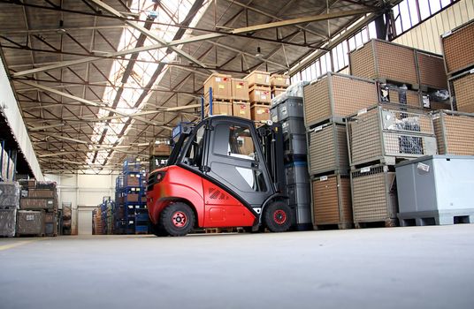 Forklift in a big warehouse with palettes