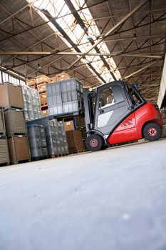 Forklift in a big warehouse with palettes