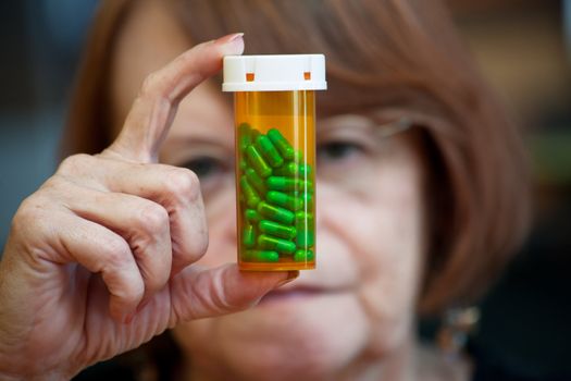 Confused woman reading instructions on prescription pill bottle