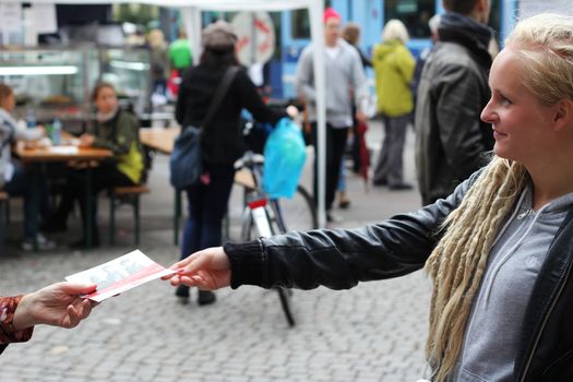 A young girl handing out flyers during the norwegian election campaign 2011.