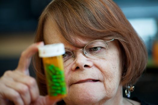 Senior woman reading instructions on prescription bottle