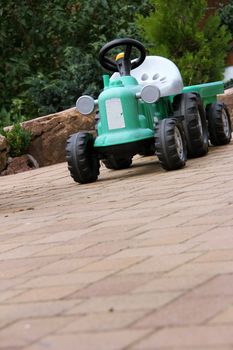 green tractor toy on the garden terrace
