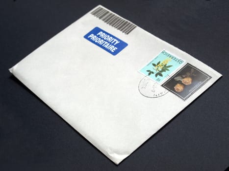 Letter envelope with postage meter and stamps