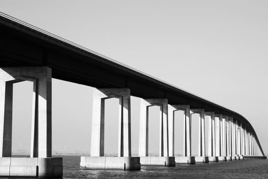 Long modern bridge built over a river.