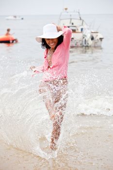 Beautiful brazilian girl splashing with water on the beach