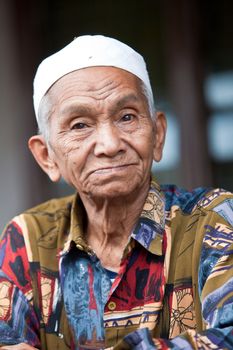Elderly man in Indonesia with little hat on