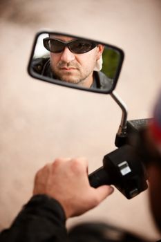 Reflection of Motorcycle Driver in Rearview Mirror