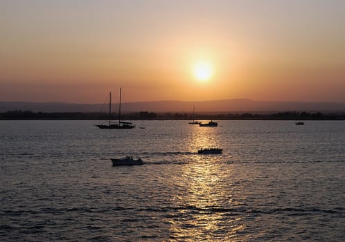 Ortigia island city of Siracusa (Italy) sunset with boats