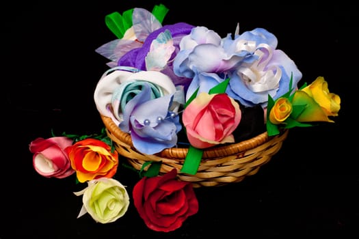 artificial handmade roses in basket on black
