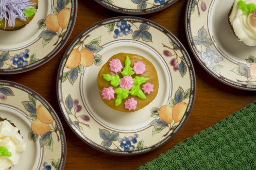 Close-up of ornately decorated cupcakes on dishes