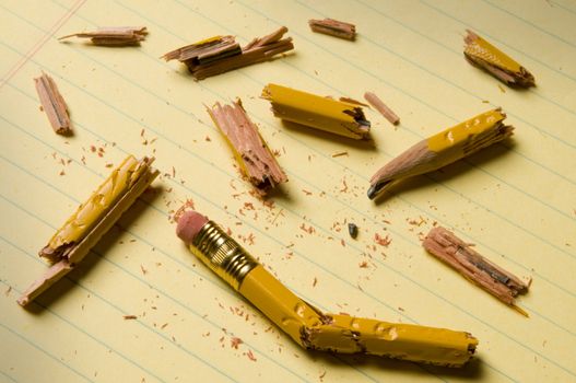 Shattered pencil fragments on a yellow legal pad, perhaps symbolizing writer's block