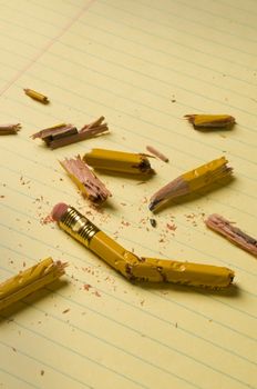Shattered pencil fragments on a yellow legal pad, perhaps symbolizing writer's block