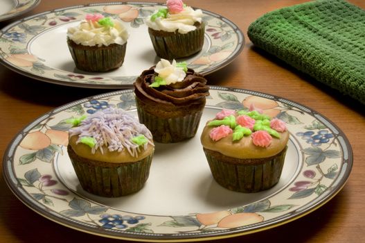 Close-up of ornately decorated cupcakes on plates