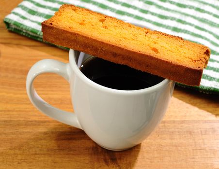 fresh cup of black coffee with butter toast cookie, kitchen towel in the background