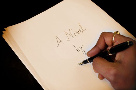 A writer signing his name on the cover page of his novel