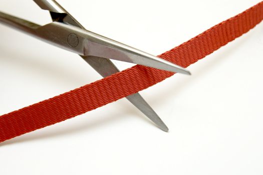 steel scissors cut red ribbon on white