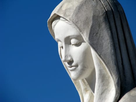 A detail of the marble statue of Our Lady Queen of Peace in the square of St James church in Medjugorje, Bosnia-Herzegovina.