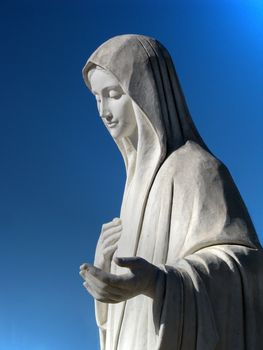 The marble statue of Our Lady Queen of Peace in the square of St James church in Medjugorje, Bosnia-Herzegovina.