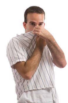 A young man holding his nose because of a bad smell, isolated against a white background