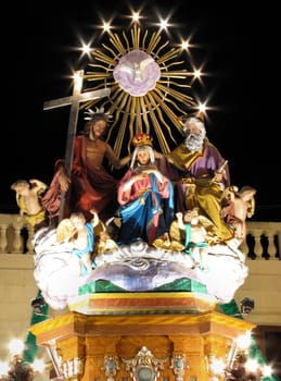 A street decoration in Qrendi, Malta depicting The Coronation of Our Lady by The Holy Trinity for the feast of Saint Mary.